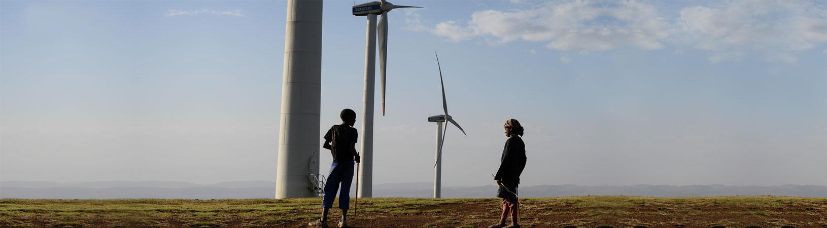 energy economic growth banner with turbines and children